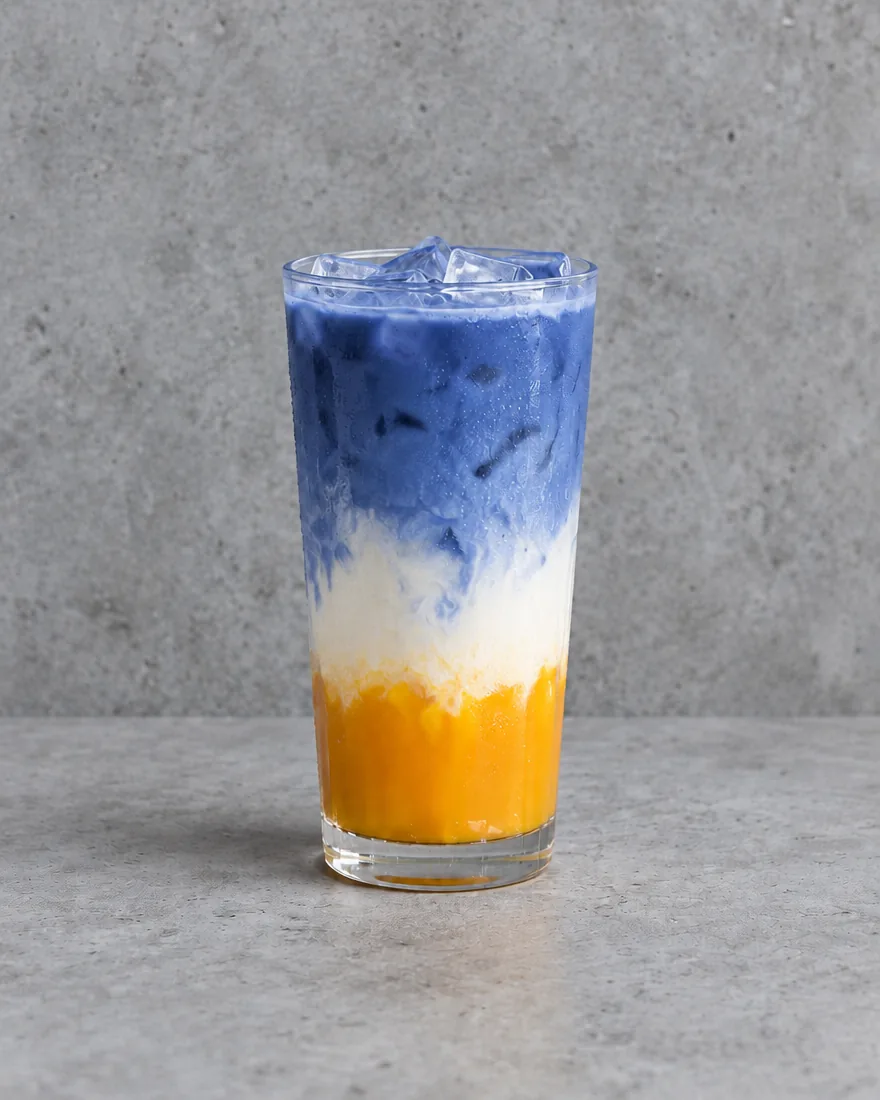 Mango Iced Blue Matcha Latte — Blue matcha latte layered over milk and mango